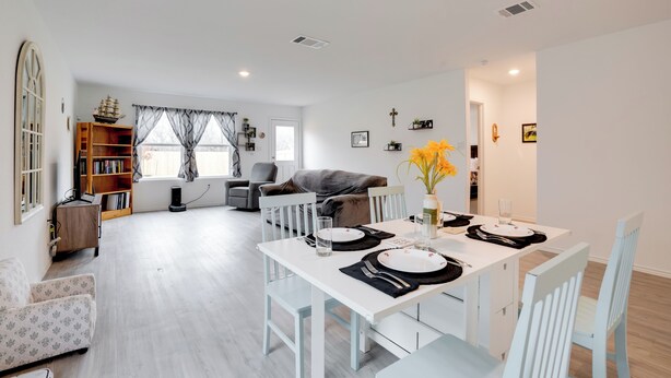 A modern living room with a dining area, white furniture, and a bookshelf. - Cozy Texas Escape Near Seaworld San Antonio! (San Antonio)