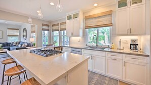 A modern kitchen with a large island, white cabinetry, and pendant lighting. - Stunning Carlsbad Gem w/ Fire Pit & Hot Tub! (Carlsbad)
