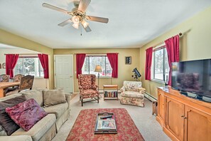 A living room with a beige sofa, a patterned rug, a wooden cabinet with a TV, and a ceiling fan. - Buena Vista Getaway ~ 1 Mi to Main Street! (Buena Vista)