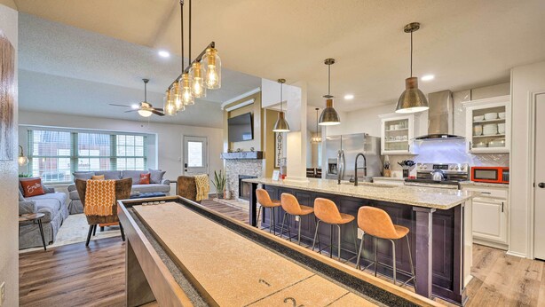 A modern kitchen with a pool table, bar stools, and a dining area with a sofa and chairs. - San Antonio Family Home w/ Game Room & Fire Pit! (San Antonio)