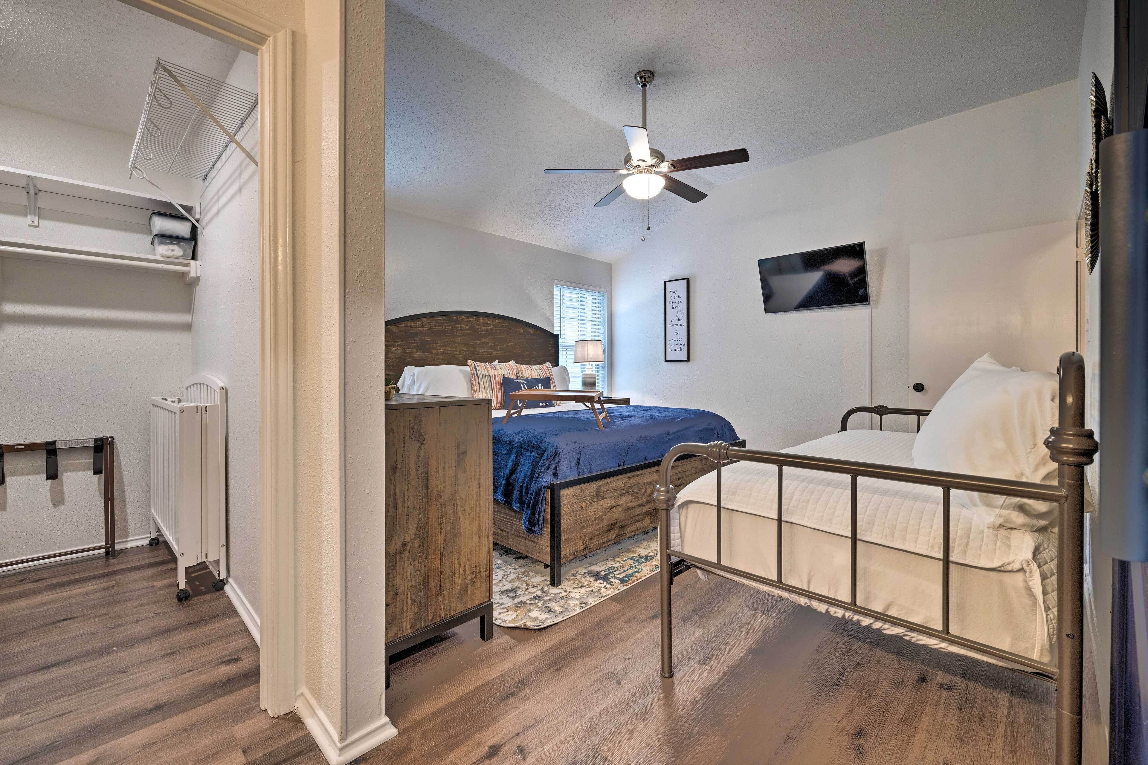 A bedroom with a bed, a ceiling fan, a radiator, and a wooden dresser.