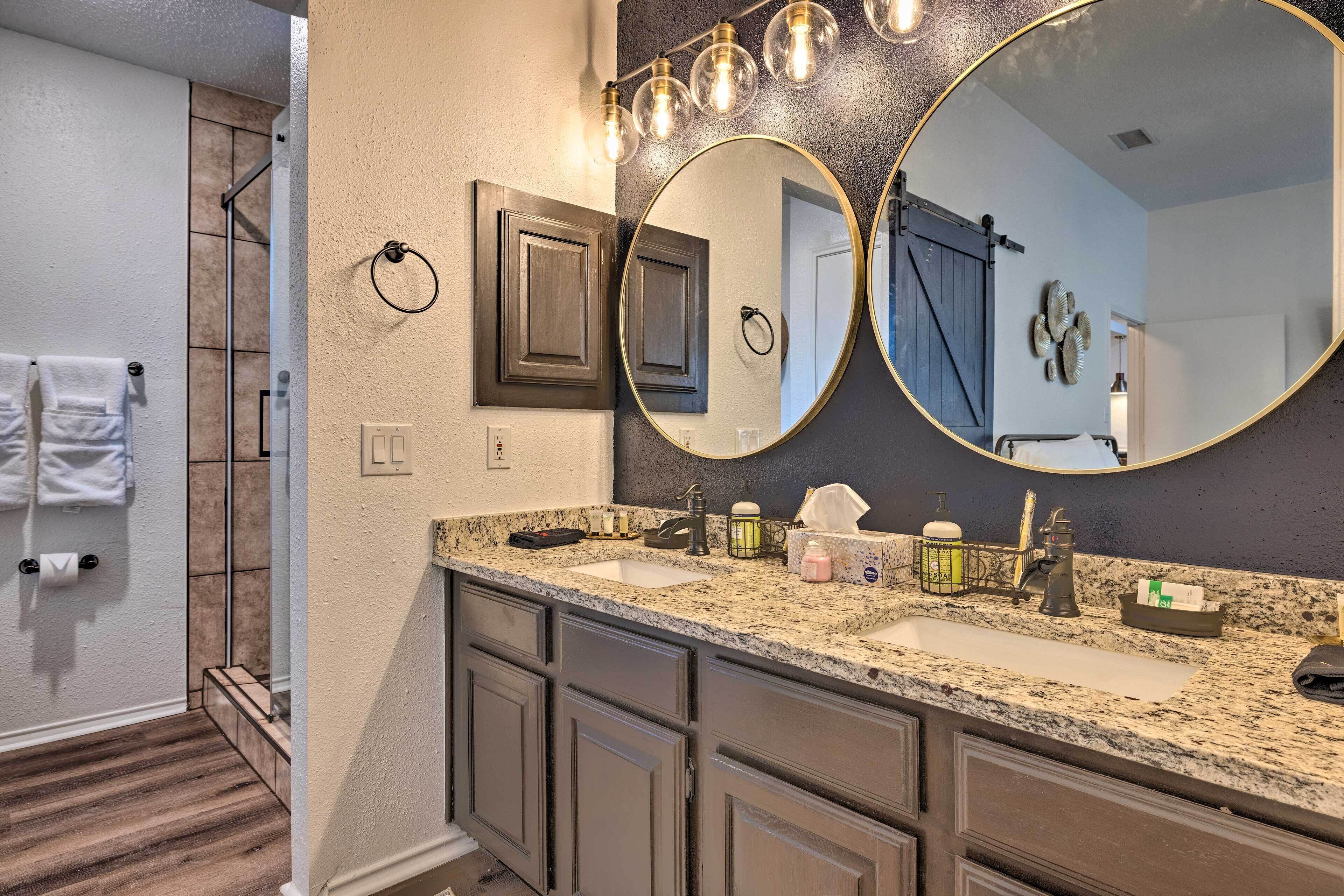 A bathroom with two sinks, a large mirror, and a towel rack.
