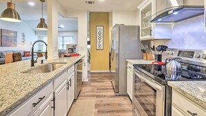 A modern kitchen with granite countertops, stainless steel appliances, and pendant lighting. - San Antonio Family Home w/ Game Room & Fire Pit! (San Antonio)