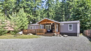 A cabin with a wooden porch, a gravel driveway, and a forested backdrop. - Packwood Cabin <20 Mi to Mt Rainier Adventure (Packwood)