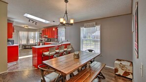 A spacious kitchen with a central island, red cabinets, and a wooden dining table with benches. - Packwood Cabin <20 Mi to Mt Rainier Adventure (Packwood)
