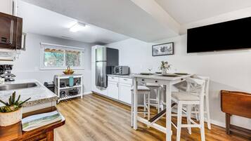 Enjoy cooking and dining in this kitchen with a central island, bar stools, and a large window offering a view of the outdoors.