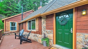 A wooden cabin with a green door, a welcome mat, and a chair outside. - Creekside Morrison Cabin ~ 9 Mi to Red Rocks Park! (Morrison)