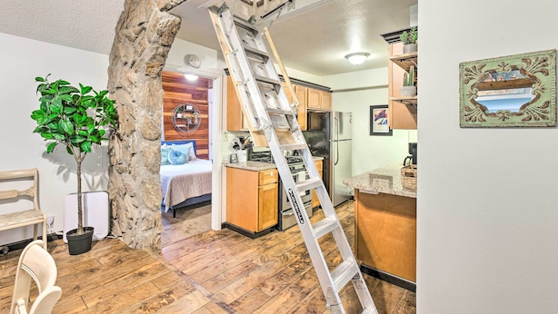 A modern kitchen with wooden cabinets, a stainless steel refrigerator, and a built-in oven. - Creekside Morrison Cabin ~ 9 Mi to Red Rocks Park! (Morrison)