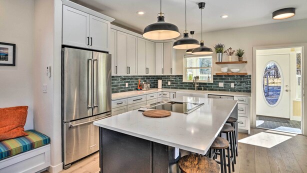 A modern kitchen with stainless steel appliances, a large island, pendant lighting, and a view through a glass door. - Charming Buena Vista Home w/ Private Hot Tub! (Buena Vista)