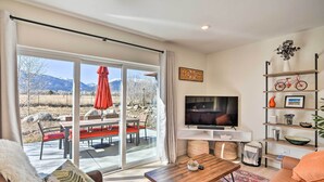 A modern living room with a large TV, a wooden coffee table, and a sofa. - Charming Buena Vista Home w/ Private Hot Tub! (Buena Vista)