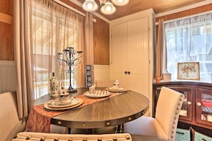 A dining area with a round table, chairs, and a decorative centerpiece.