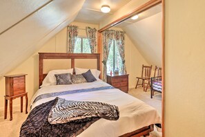 Une chambre à coucher avec un lit en bois, une table de chevet, une commode et une chaise.