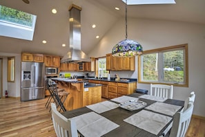 A modern kitchen with wooden cabinets, stainless steel appliances, and a large island. - Idyllic Retreat ~ 20 Mi to Olympic National Park! (Port Angeles)