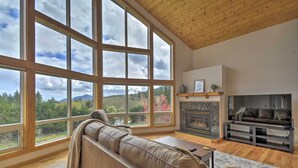 Ein geräumiges Wohnzimmer mit großem Fenster, Kamin und einer Ledersofa.
