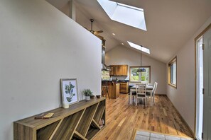 A spacious kitchen with wooden cabinets, a dining area with chairs, and a skylight.