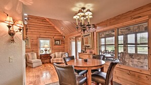 A wooden interior with a dining table, chairs, and a chandelier. - 40-acre Farm w/ Animals & Fishing in Sebring! (Sebring)