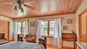 A bedroom with wooden flooring, a bed, a dresser, a desk, and a ceiling fan. - 40-acre Farm w/ Animals & Fishing in Sebring! (Sebring)