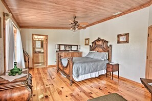A bedroom with a wooden ceiling, a bed with a headboard, a nightstand, a dresser, a mirror, and a window with curtains. - 40-acre Farm w/ Animals & Fishing in Sebring! (Sebring)