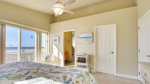 A bedroom with a bed, a ceiling fan, a door, and a view of the beach. - Quiet Waterfront Escape w/ Hot Tub & Beach Access! (Gold Beach)