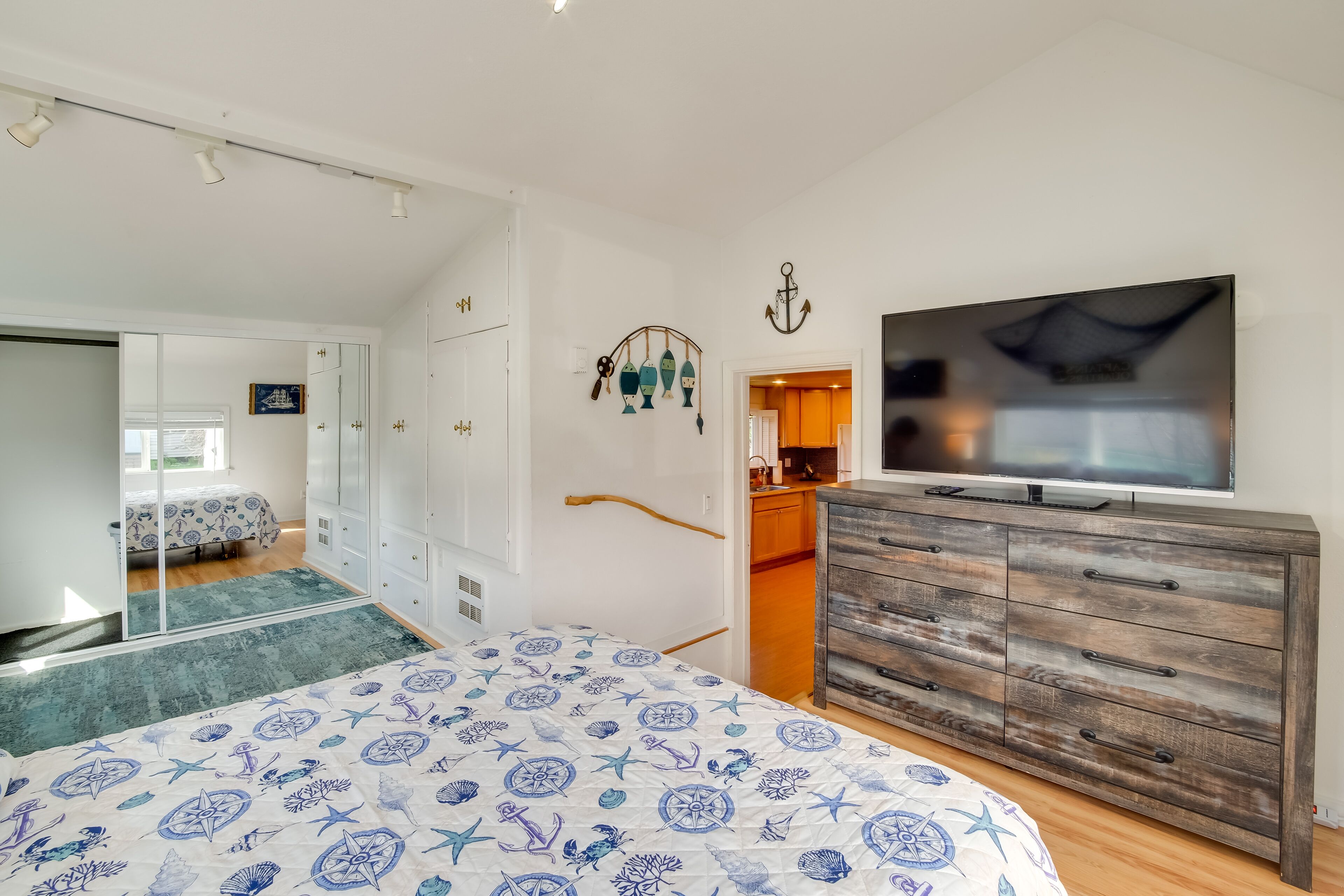 Een slaapkamer met een bed, een kaptafel, een televisie en een kledingkast.