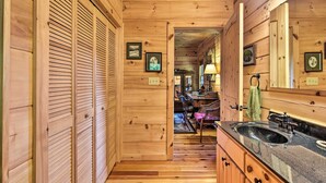 A wooden interior with a wooden floor, a sink, cabinets, and a mirror. - Cabin w/ BBQ + Games - Walk to Blue Ridge Parkway! (Sylva)