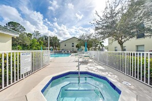 A pool area with a sign detailing spa rules, surrounded by a white fence and trees. - Naples Condo w/ Pool Access ~ 6 Mi to Beach (Naples)