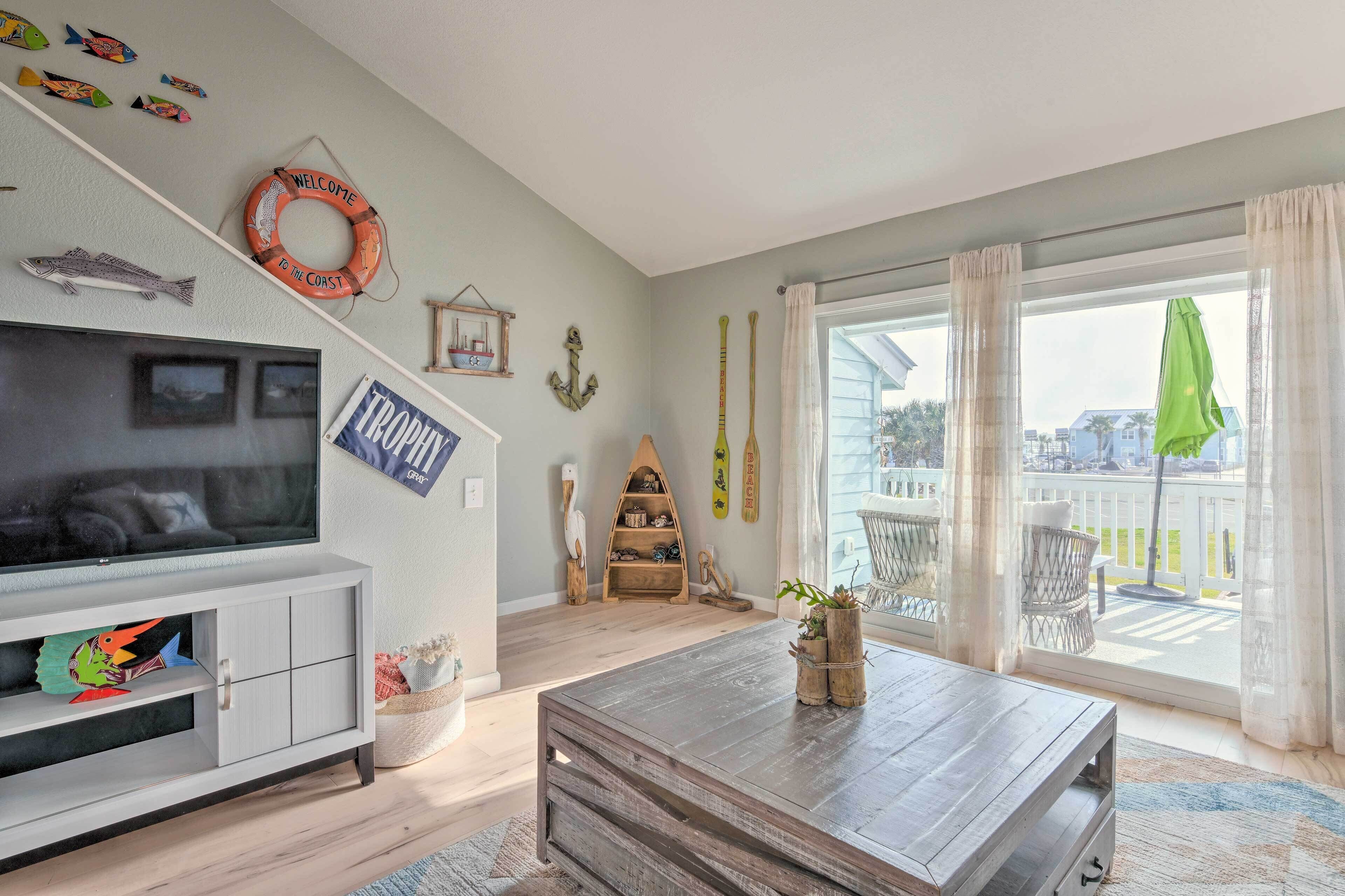 Una sala de estar con televisor, mesa de centro de madera y vistas al exterior.