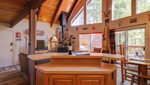 Een ruime keuken met houten kastjes, een inbouwfornuis en grote ramen met uitzicht op de omgeving.