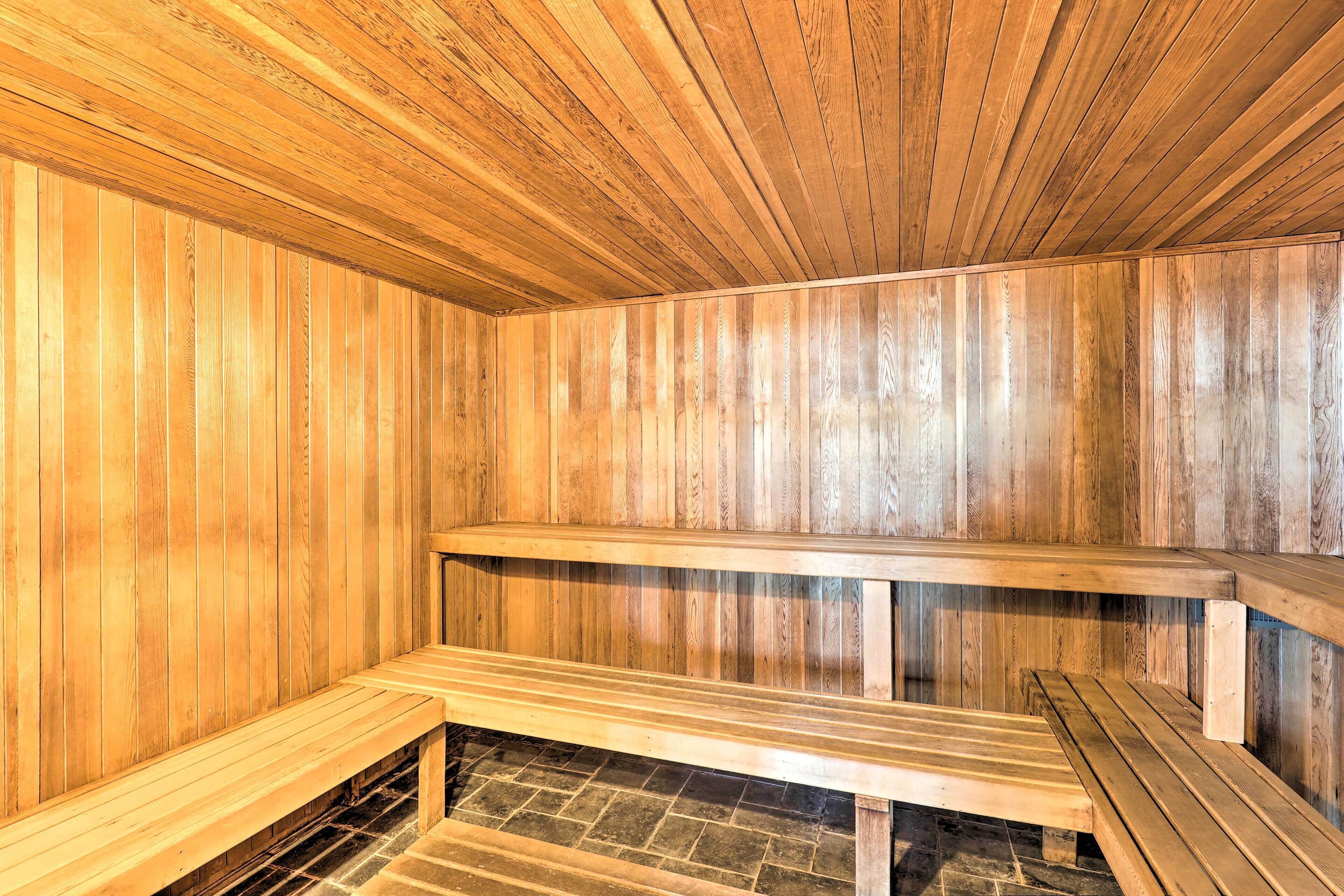 A sauna with wooden benches and a stone floor.