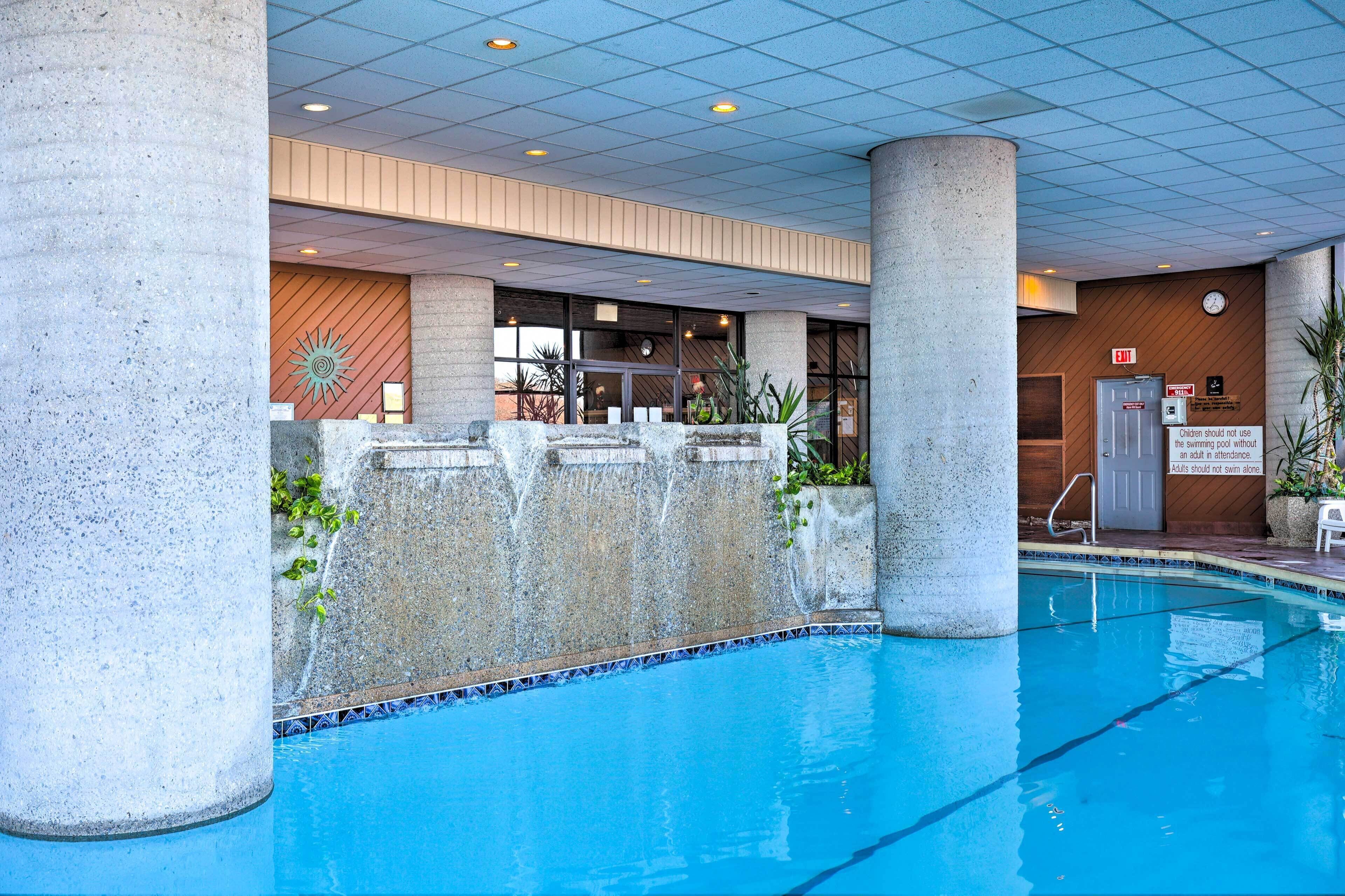 A pool area with a tiled ceiling, concrete pillars, and a sign indicating no swimming for children under 12.