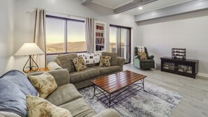 A living room with a sofa, coffee table, and a bookshelf. - Near Sugar Mountain: Renovated Condo w/ Views! (Banner Elk)