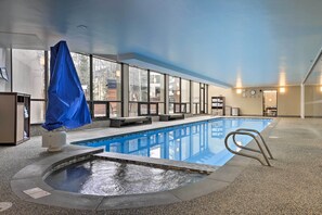 Une piscine intérieure dotée d’un jacuzzi, d’un espace détente et d’un banc abrité.