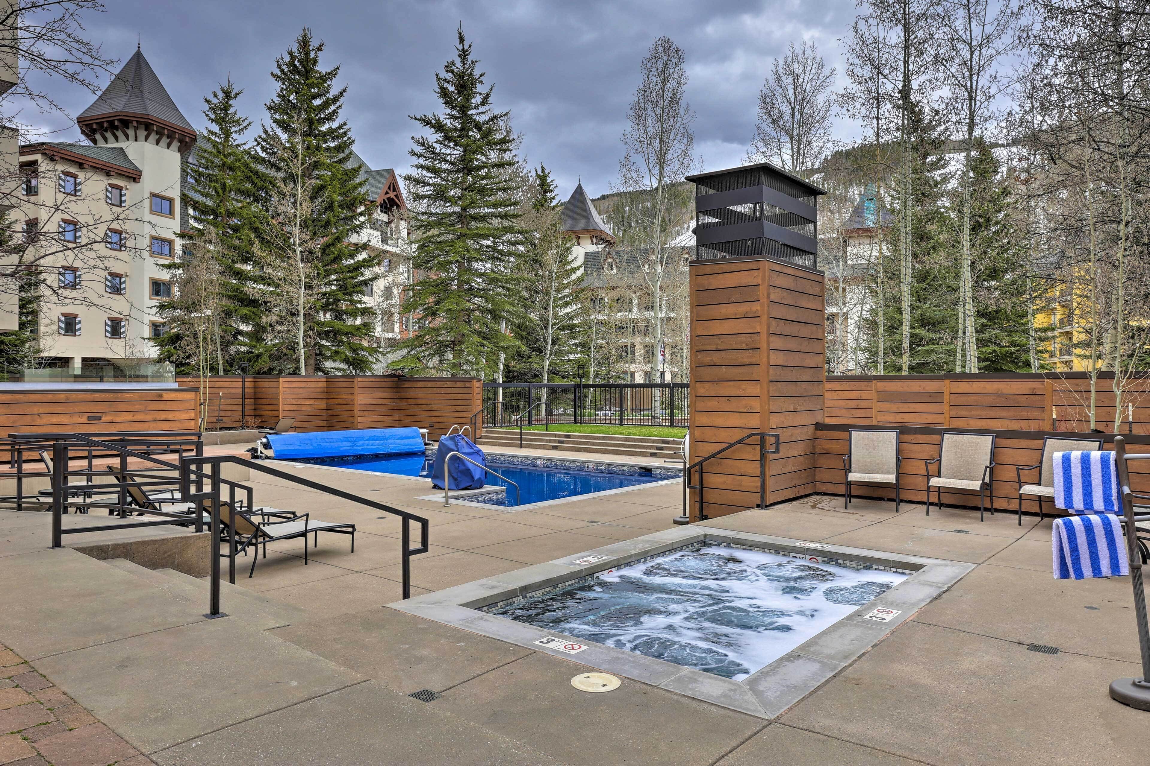 A spa area with a hot tub, lounge chairs, and a pool.