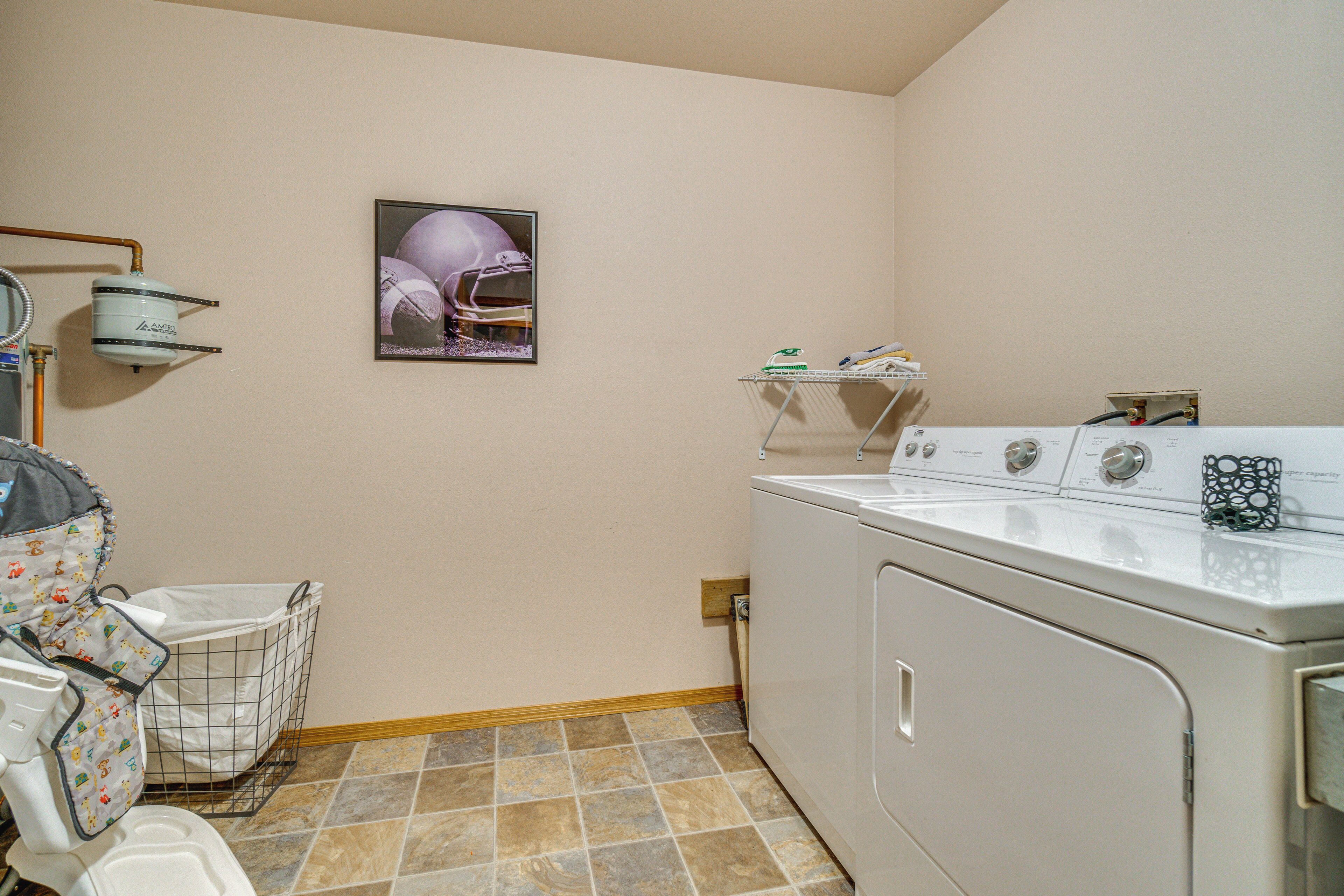 A laundry area with a washing machine, a drying rack, and a baby changing station.