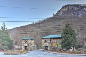 A stone building with a green roof, a sign reading 'CHIMNEY ROCK AT CHIMNEY ROCK STATE PARK', and a 'NARROW BRIDGE' warning sign. - Lake Lure Log Cabin W/fire pit and Hiking Nearby (Lake Lure)