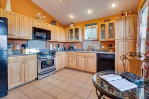 Una cocina con armarios de madera, microondas, estufa y lavavajillas.