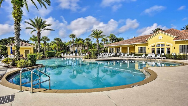 A pool area with lounge chairs and a yellow building. - Kissimmee Retreat w/ Pool Access < 4 Mi to Disney! (Kissimmee)