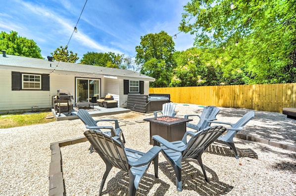 A backyard with a patio area, outdoor furniture, and a barbecue grill.