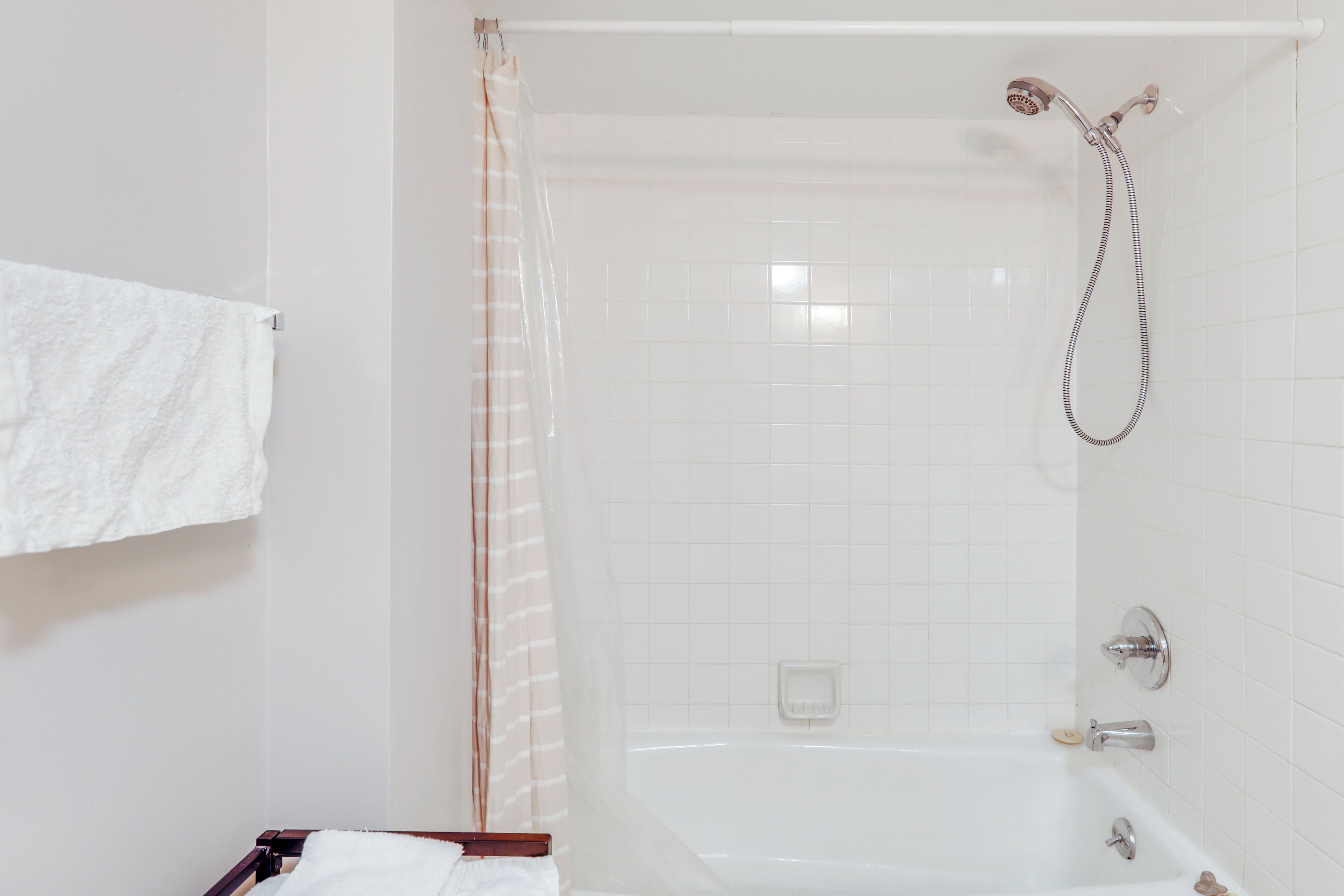 Une salle de bain avec une baignoire, une douche et un porte-serviettes.