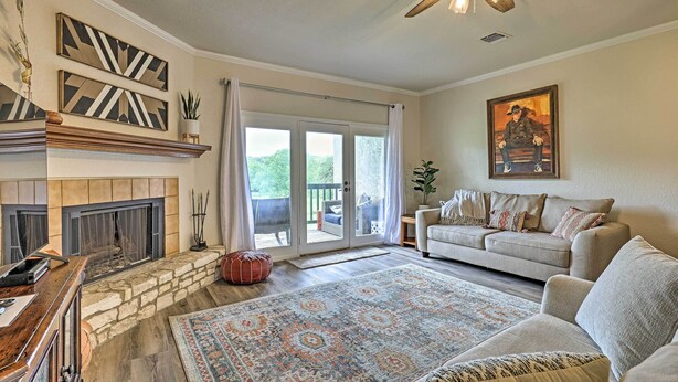 A living room with a fireplace, a sofa, a rug, and a ceiling fan.