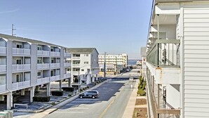Un hotel de varios pisos con balcones, estacionamiento y vista al océano.