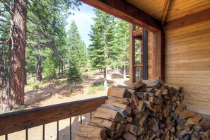 A wooden cabin with a deck overlooking a forest. - Inviting Ski Getaway < 1 Mile to Northstar Resort! (Truckee)