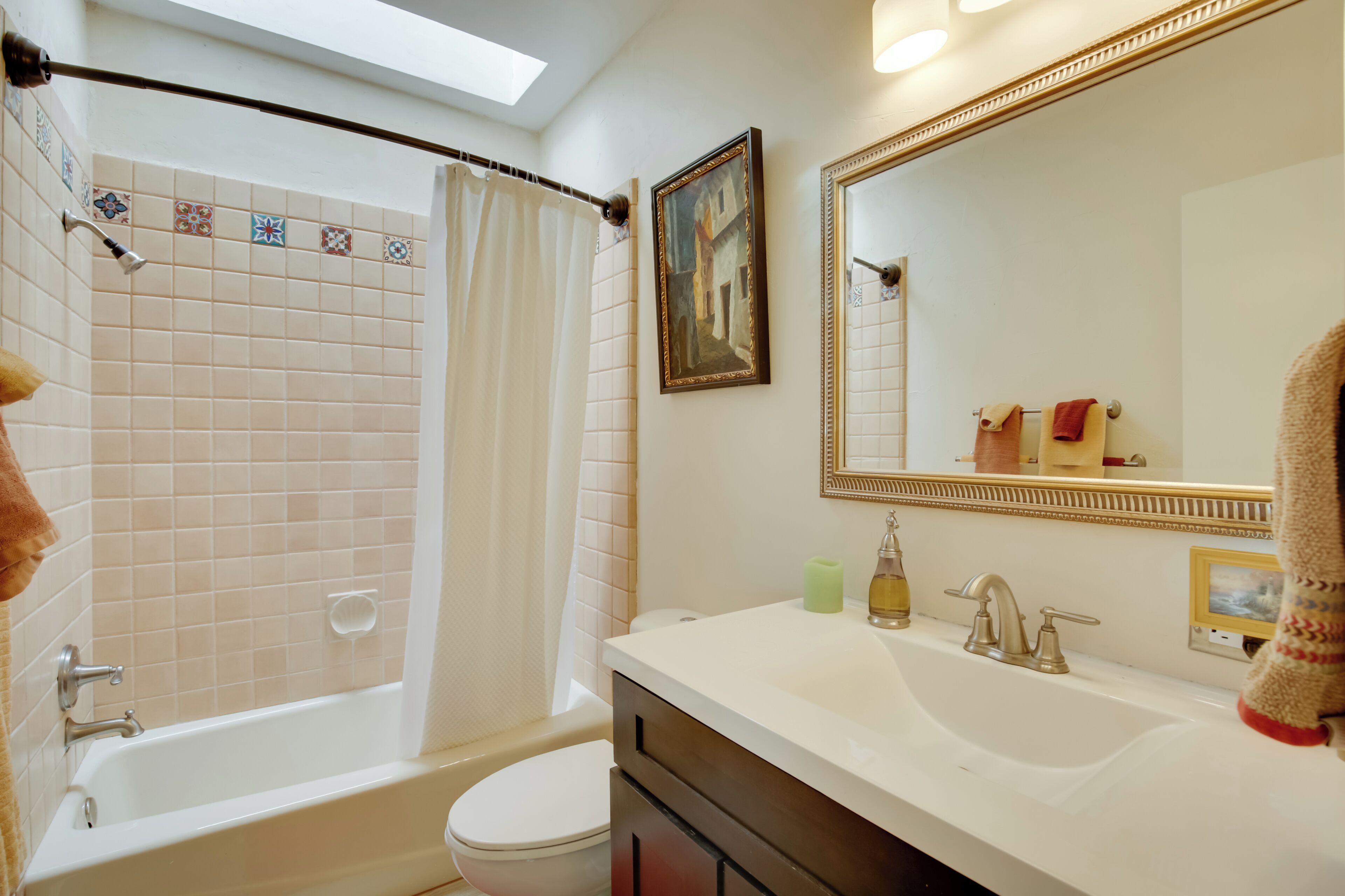 A bathroom with a bathtub, toilet, and sink.