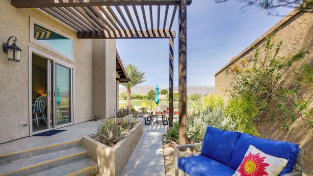 A patio with a blue sofa, steps leading to a door, and a garden area with plants. - 'roadrunner Roost' at Rams Hill Golf Resort! (Borrego Springs)