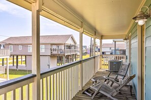 A wooden deck with outdoor seating, a covered porch, and a view of neighboring buildings. - Unwind Poolside, Walk to Beach! Galveston Retreat (Galveston)