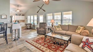 A spacious living room with a high ceiling, a dining area, and a kitchen. - Unwind Poolside, Walk to Beach! Galveston Retreat (Galveston)