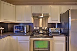 A kitchen with white cabinetry, a stainless steel range hood, a microwave, a toaster, and a stove. - Resort Perks & Lake Access: Poconos Retreat (Pocono Summit)