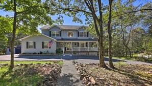 A two-story house with a front porch, a stone pathway, and a flag. - Poconos Escape w/ Hot Tub & Fire Pit (Albrightsville)