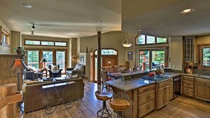 A spacious kitchen with a large island, wooden cabinets, and a dining area with a sofa and chairs. - Beautiful Breck Retreat: Walk to Gondola & Main St (Breckenridge)