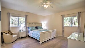 A bedroom with a bed, nightstands, a chair, and a desk. - Indian Rocks Beach Oasis - 2 Blocks to Beach! (Indian Rocks Beach)